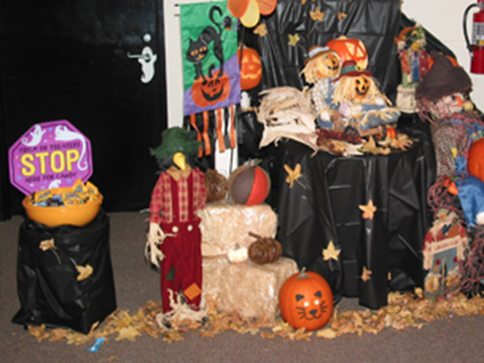 a child standing next to a display of pumpkins and other objects